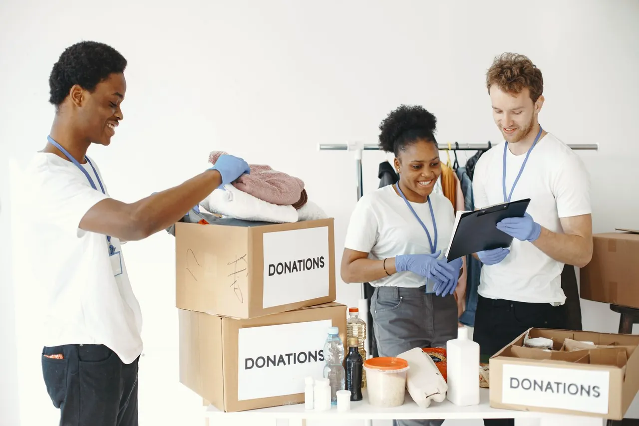 Volunteers organizing donated supplies and checking a clipboard
